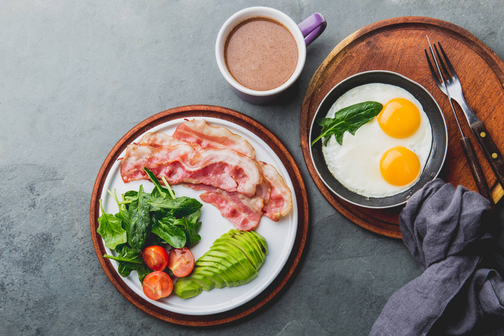 Ketogenic diet breakfast. fried egg, bacon and avocado, spinach and bulletproof coffee. Low carb high fat breakfast